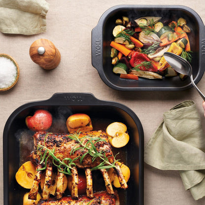 Woll Roast it! small and medium roasting pans styled on a dinner table for oven-to-table serving